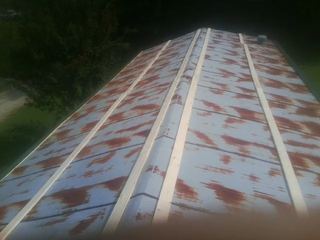 Rusted metal roof panels with new wood purlins before replacement — Storm Damage Roof Repair in Chemult by Roofing Brothers