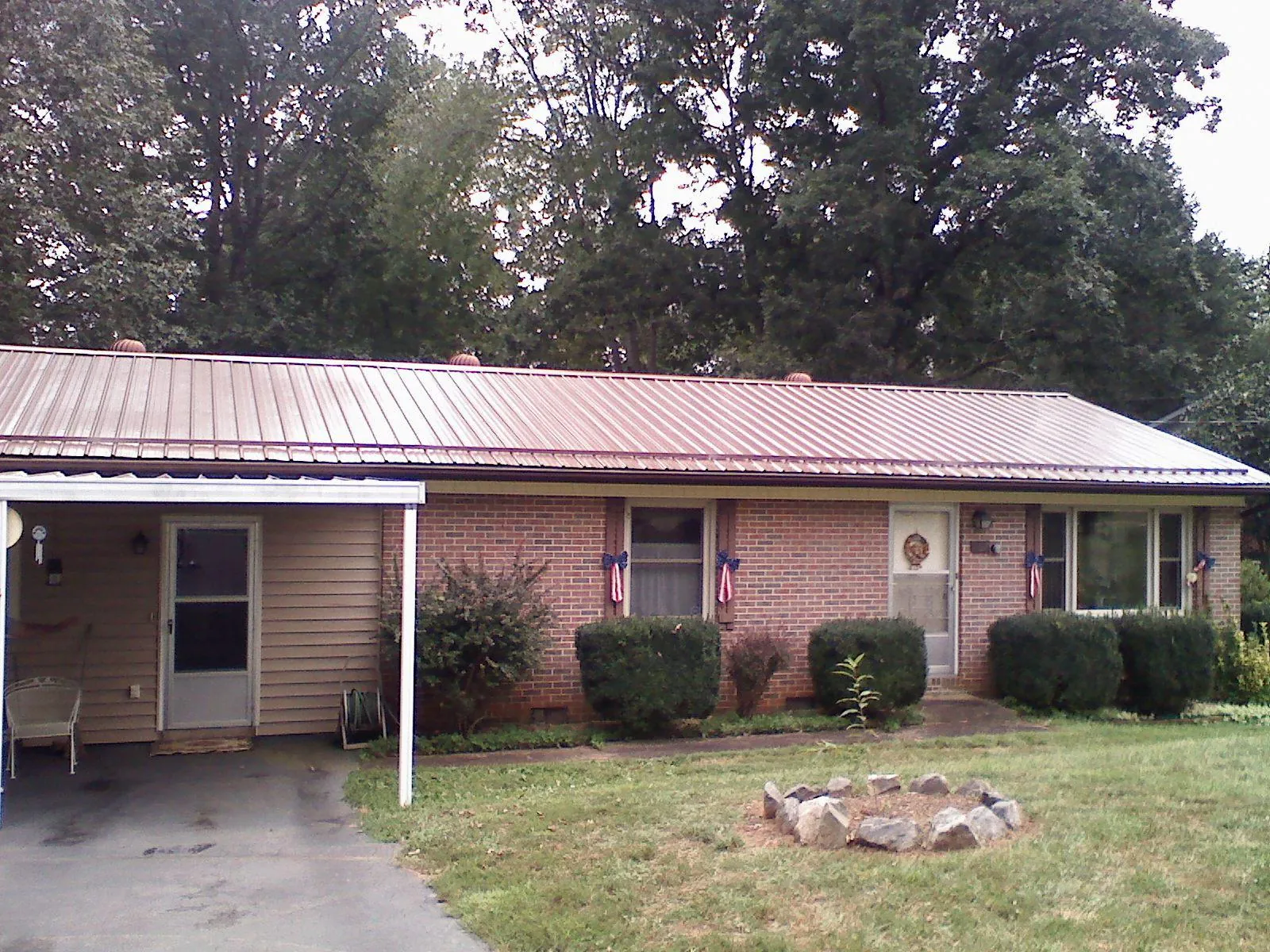 Bronze metal roof and carport on a brick ranch home — Roof Repair work by our crew in Chemult